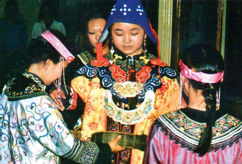 Девушки-подружки надевают на невесту головной убор и пояс. 2000. Нанайцы. Фото В.А. Спидлена